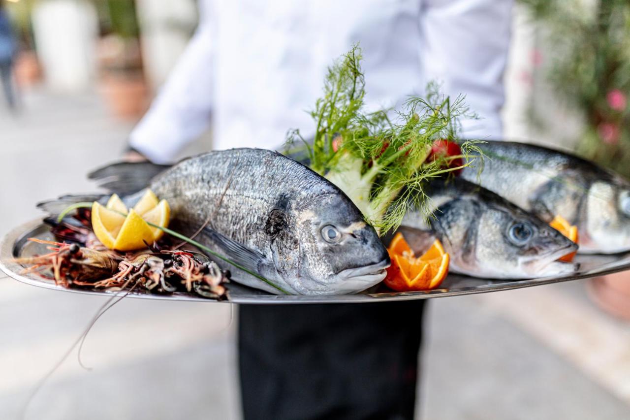 בלצ'יק Lighthouse Golf & Spa Hotel מראה חיצוני תמונה A waiter holding a platter of fish